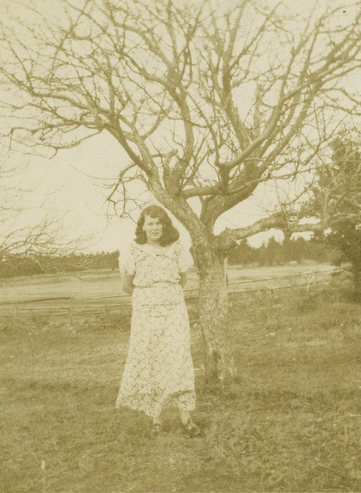 Jean beside a leafless tree