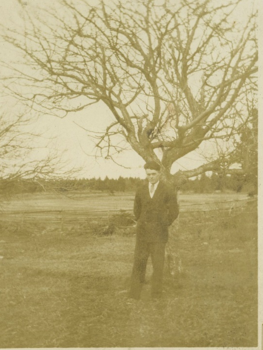 Jimmy beside a leafless tree